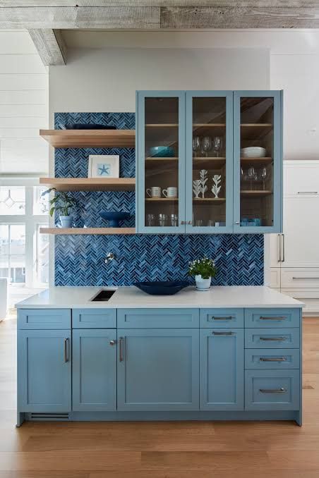 Blue lower cabinets with glass-door uppers and floating wood shelves (example style photo)
