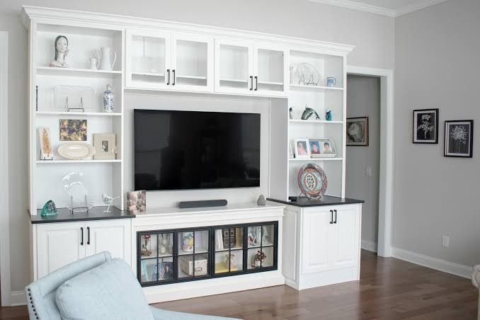 White entertainment center with glass-door upper cabinets and display shelves (example style photo)